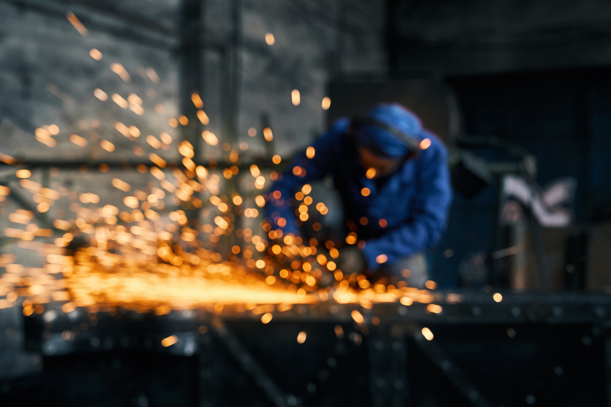 Worker doing gate by electric steel cutter machine.